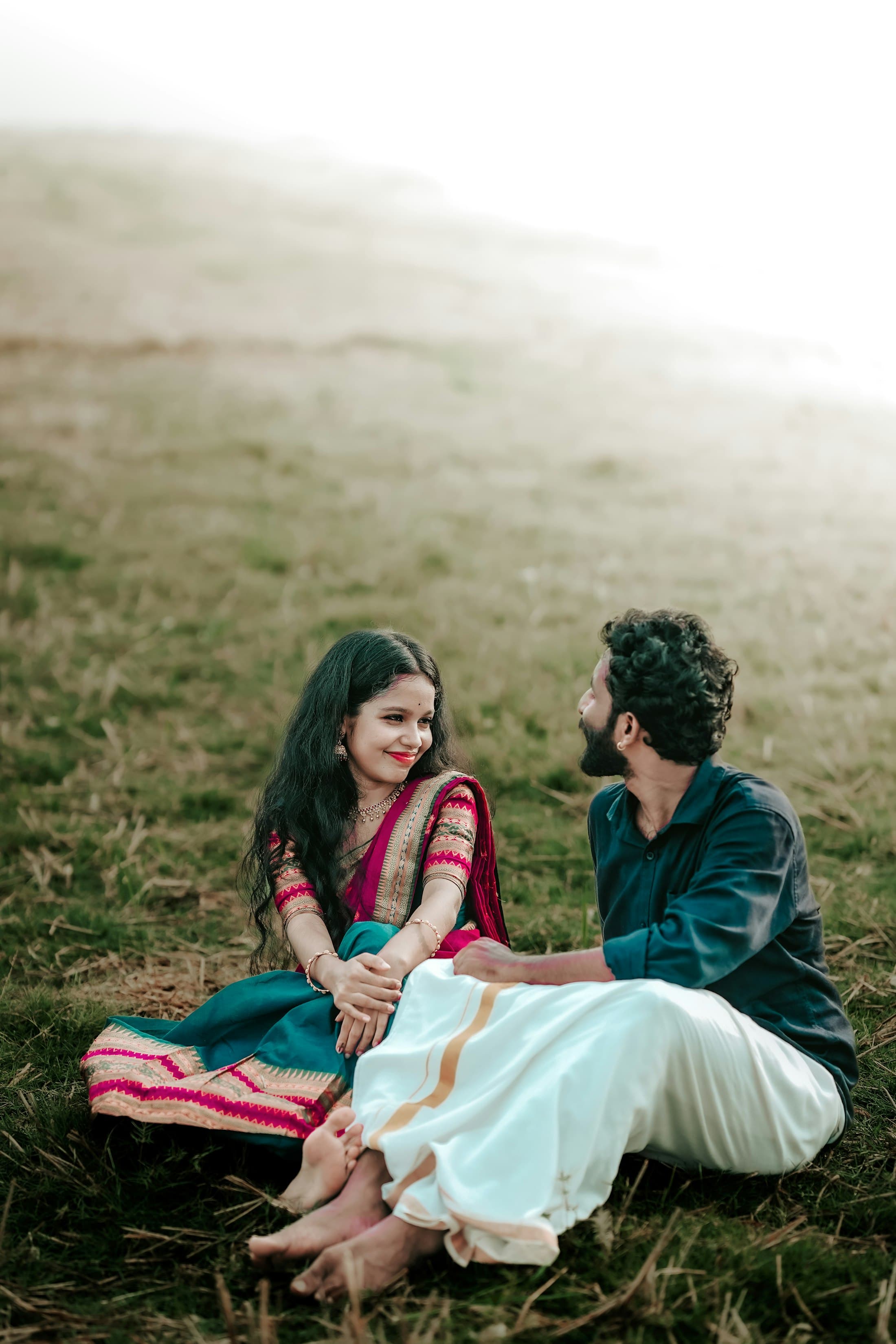 ಹುಲ್ಲಿನ ಮೇಲೆ ಜೊತೆಯಾಗಿ ಕುಳಿತ ದಂಪತಿ