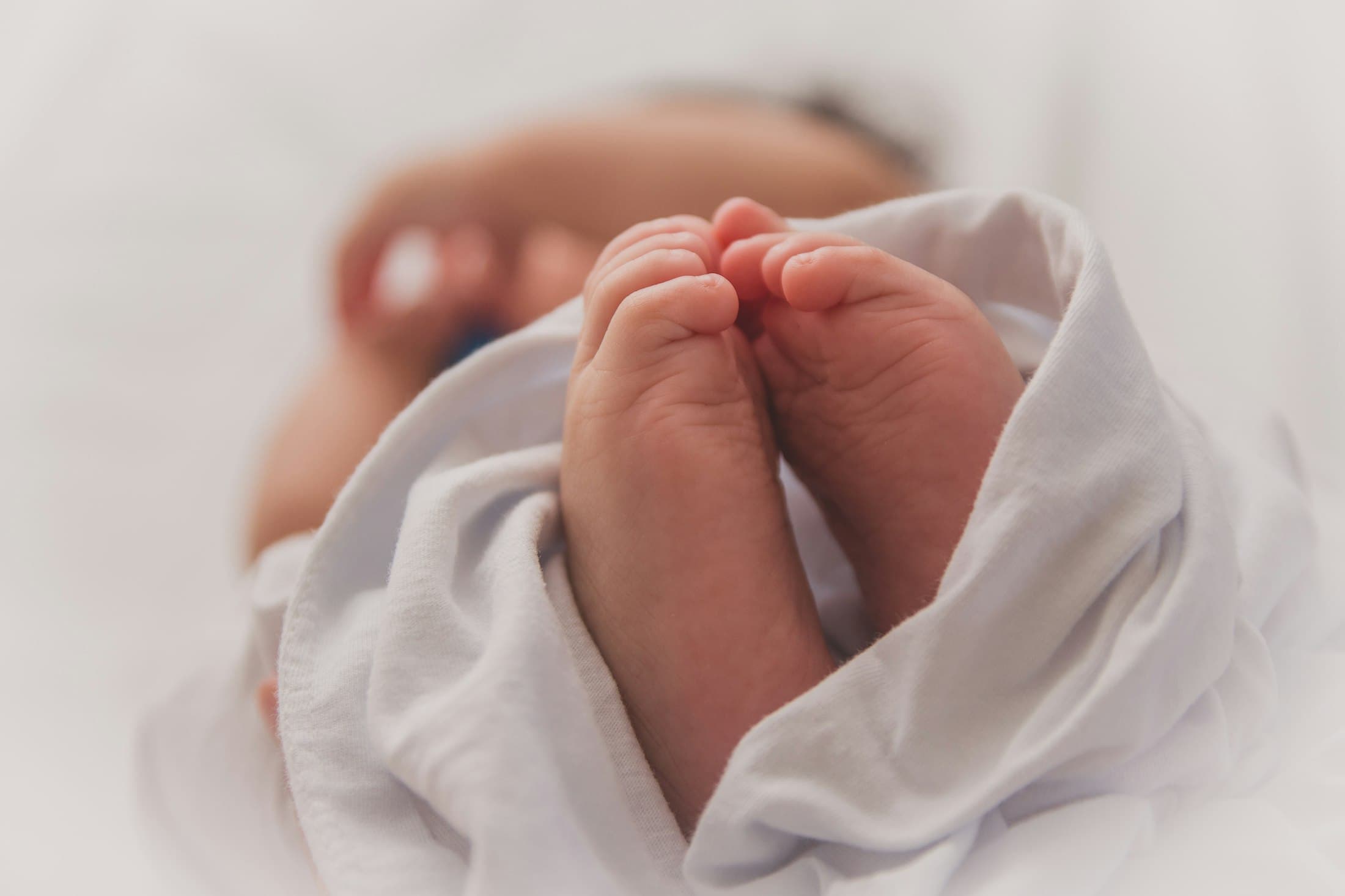 A newborn’s feet wrapped in a soft blanket