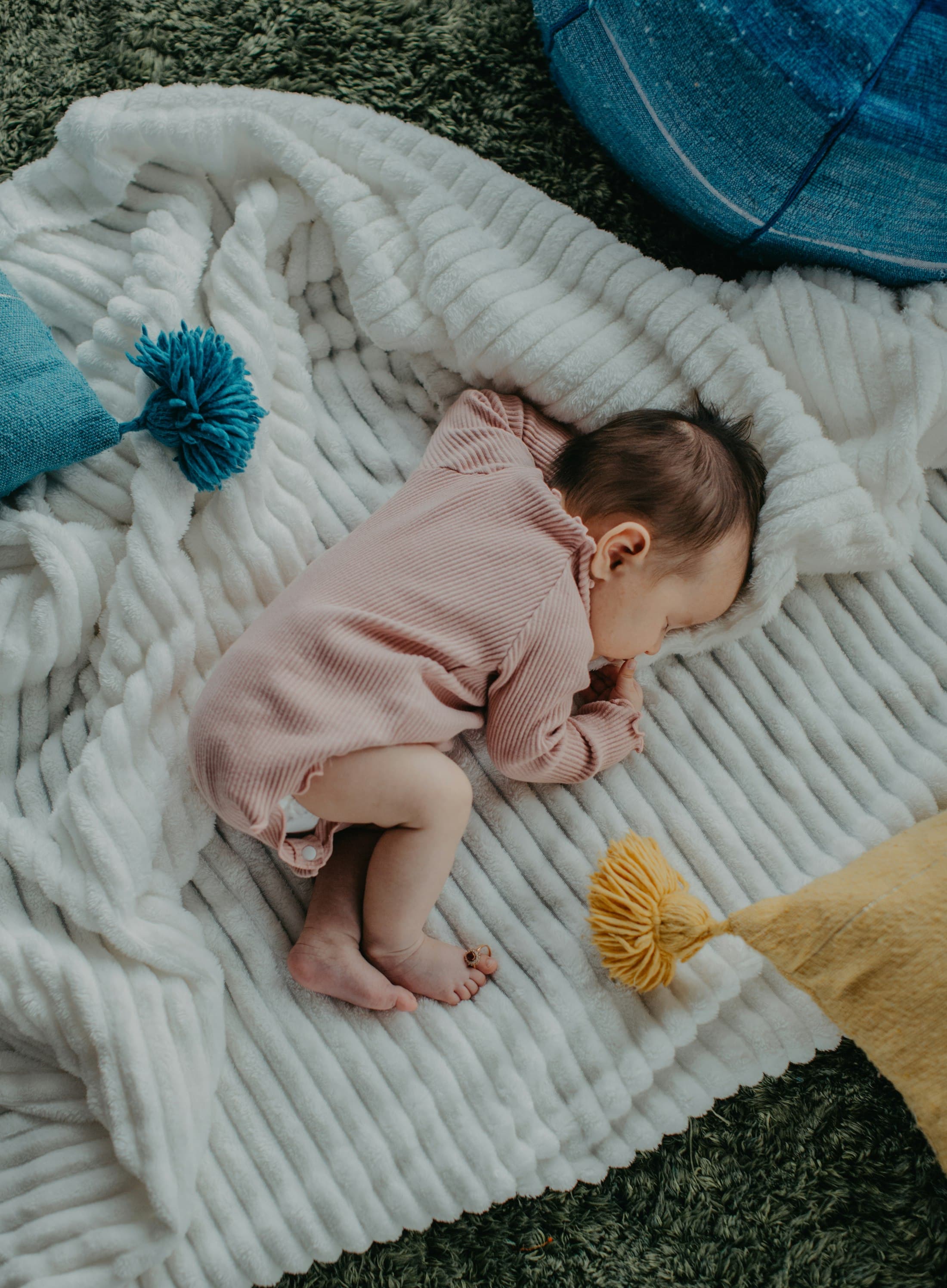 A newborn baby asleep on a blanket